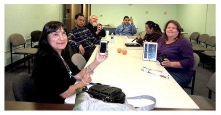 the apple devices club meeting with everyone holding up their apple devices and smiling.